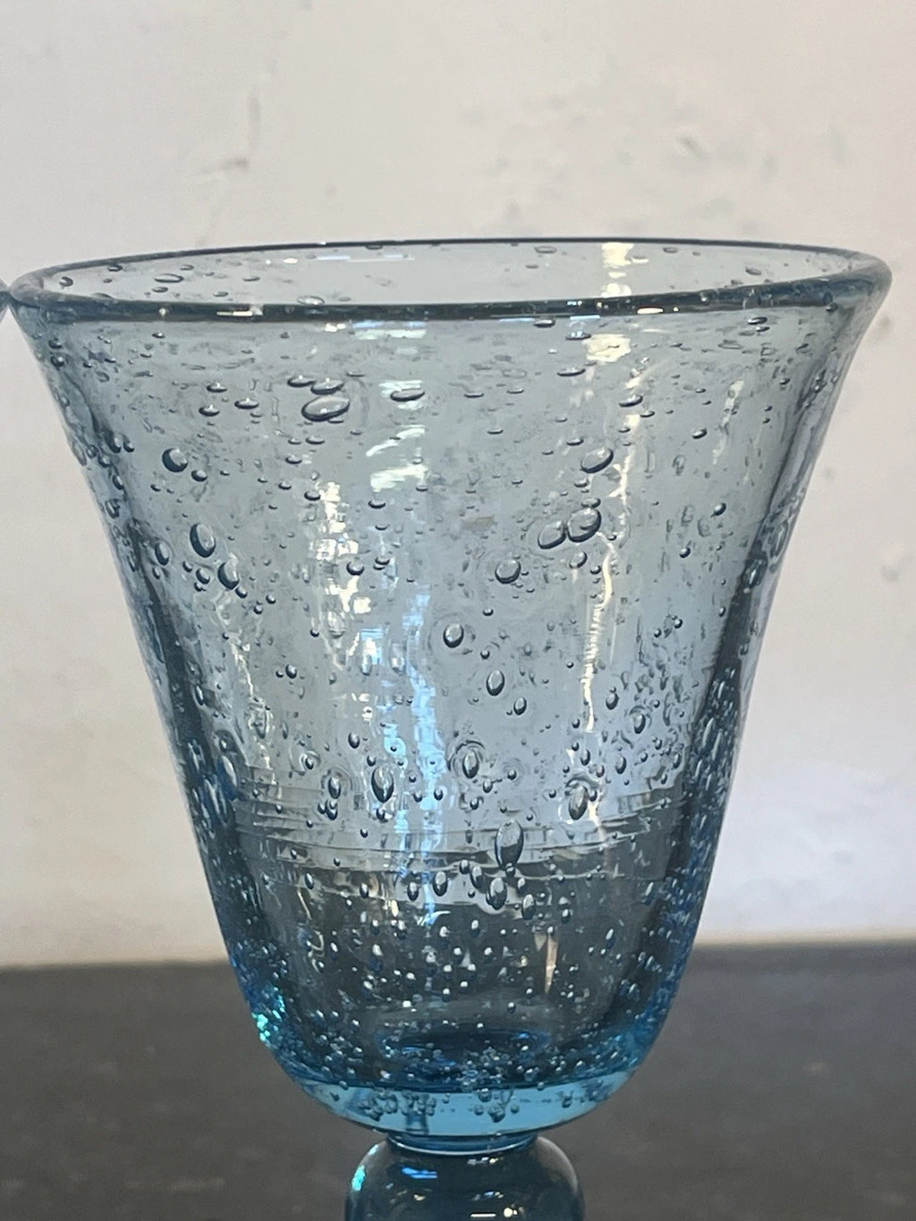 Close detail of the hand-blown bubble texture in a Biot wine goblet