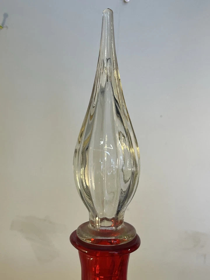 Side view showing the ruby red bottle and clear glass stopper