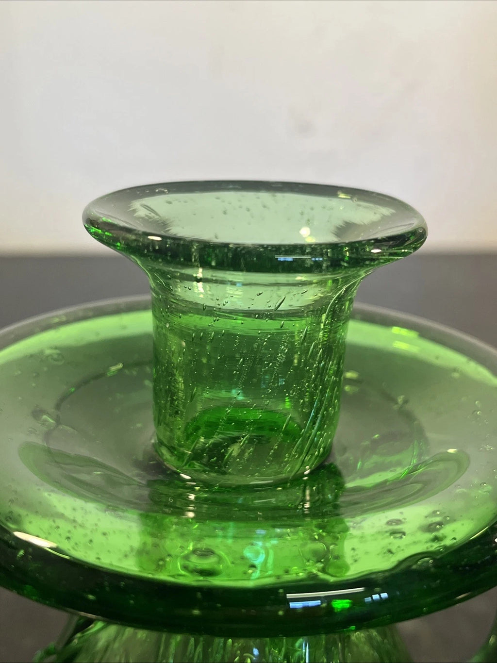 Close view of the raised candle cup and broad glass drip tray