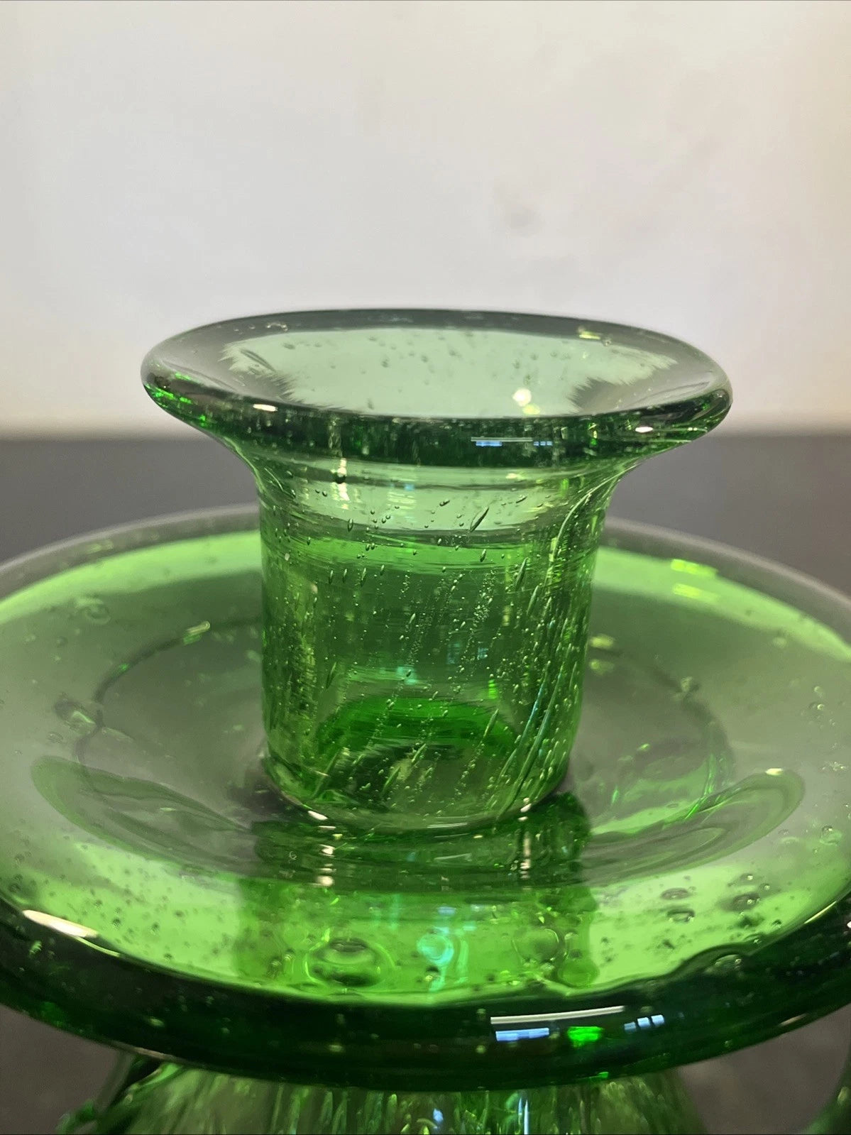 Close view of the raised candle cup and broad glass drip tray