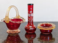 Cranberry art-glass trio showing the basket, floral bud vase and scalloped bowl